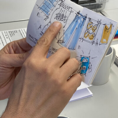 Workshop participant pointing to a detail of a zine about household chores