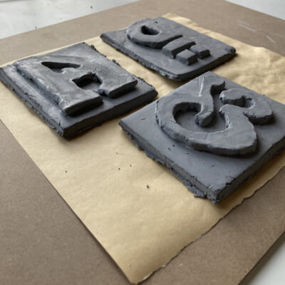 Clay printing blocks of letterforms drawn from foundation stones