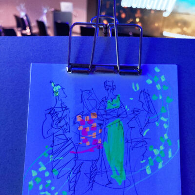 Sketch of pre-event chat, drawn in biro and highlighter, glowing under blue light